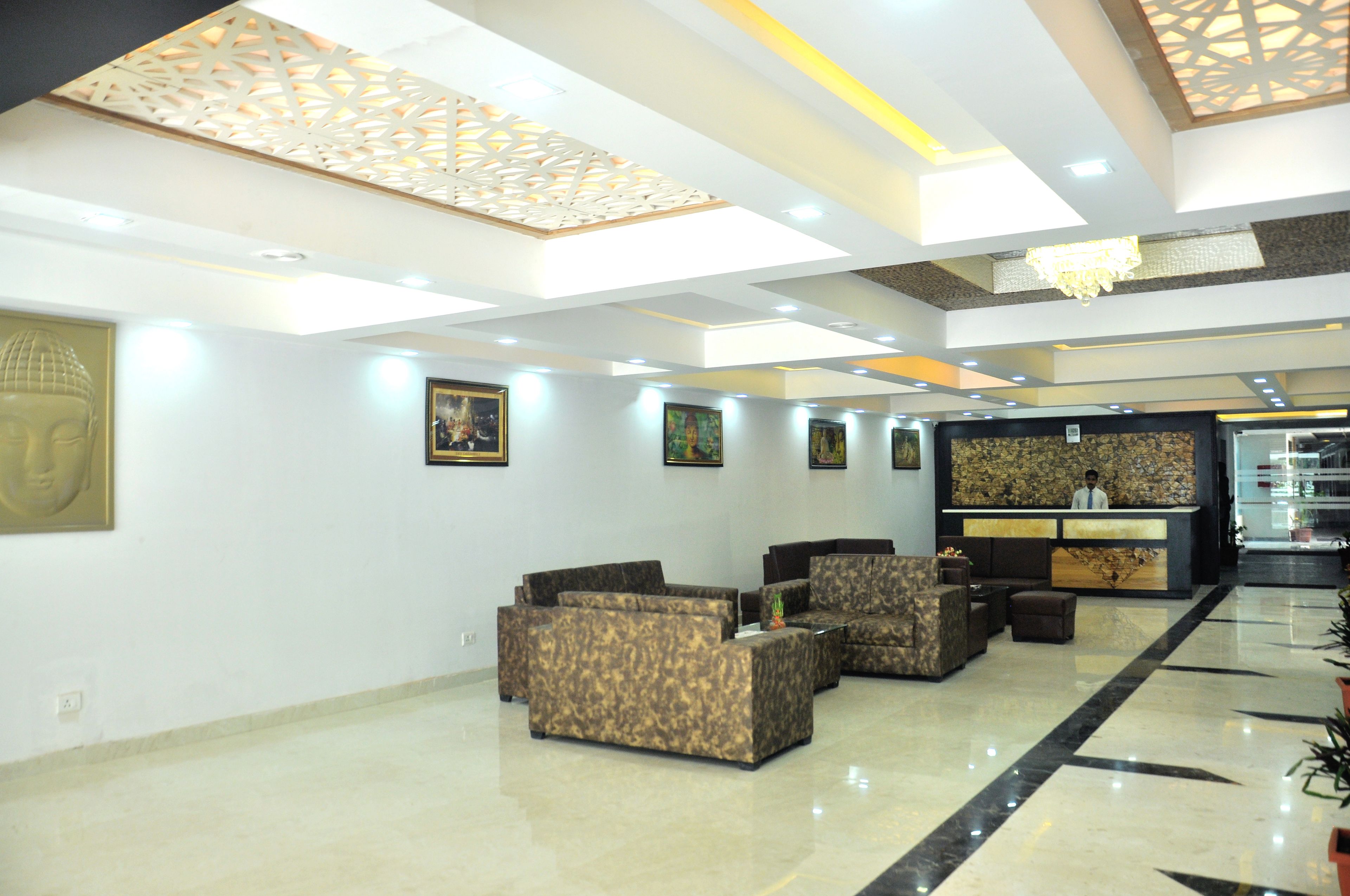 A lobby with a reception desk, seating area, and artwork on the walls.