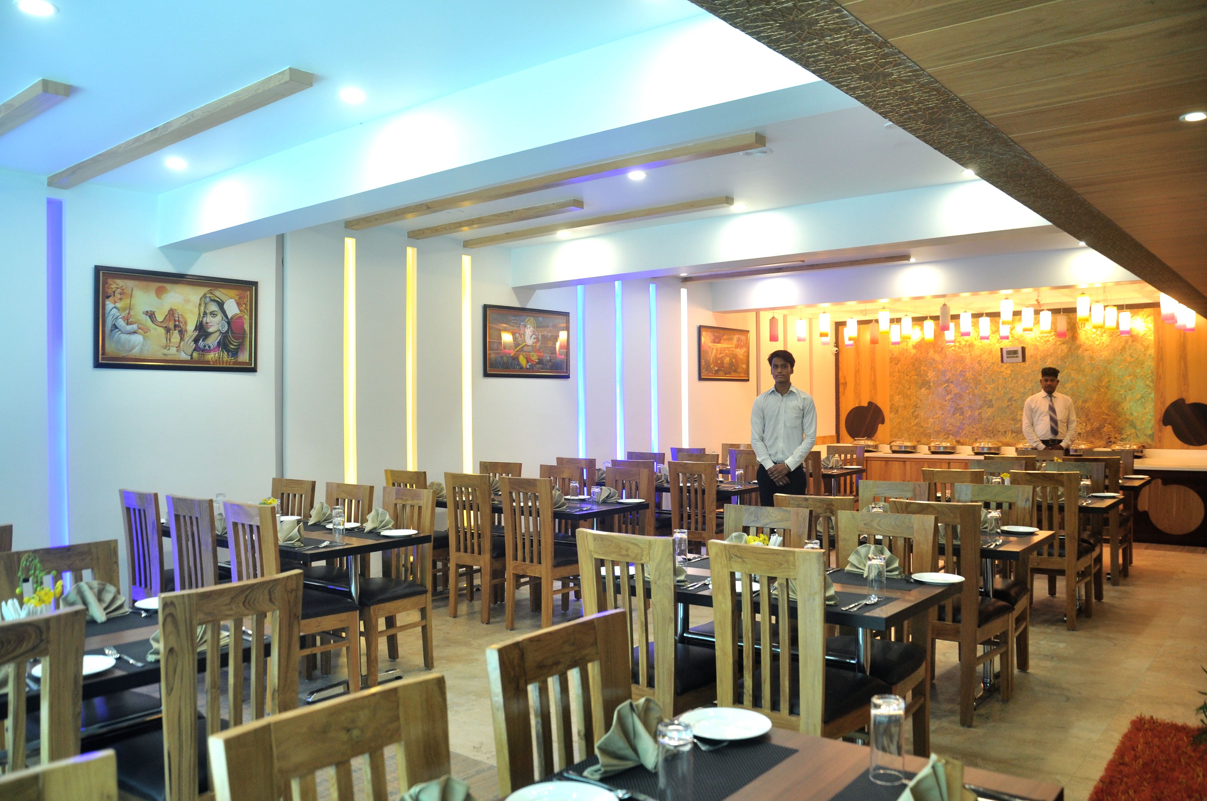 A restaurant with multiple tables and chairs, wooden decor, and wall-mounted artwork.