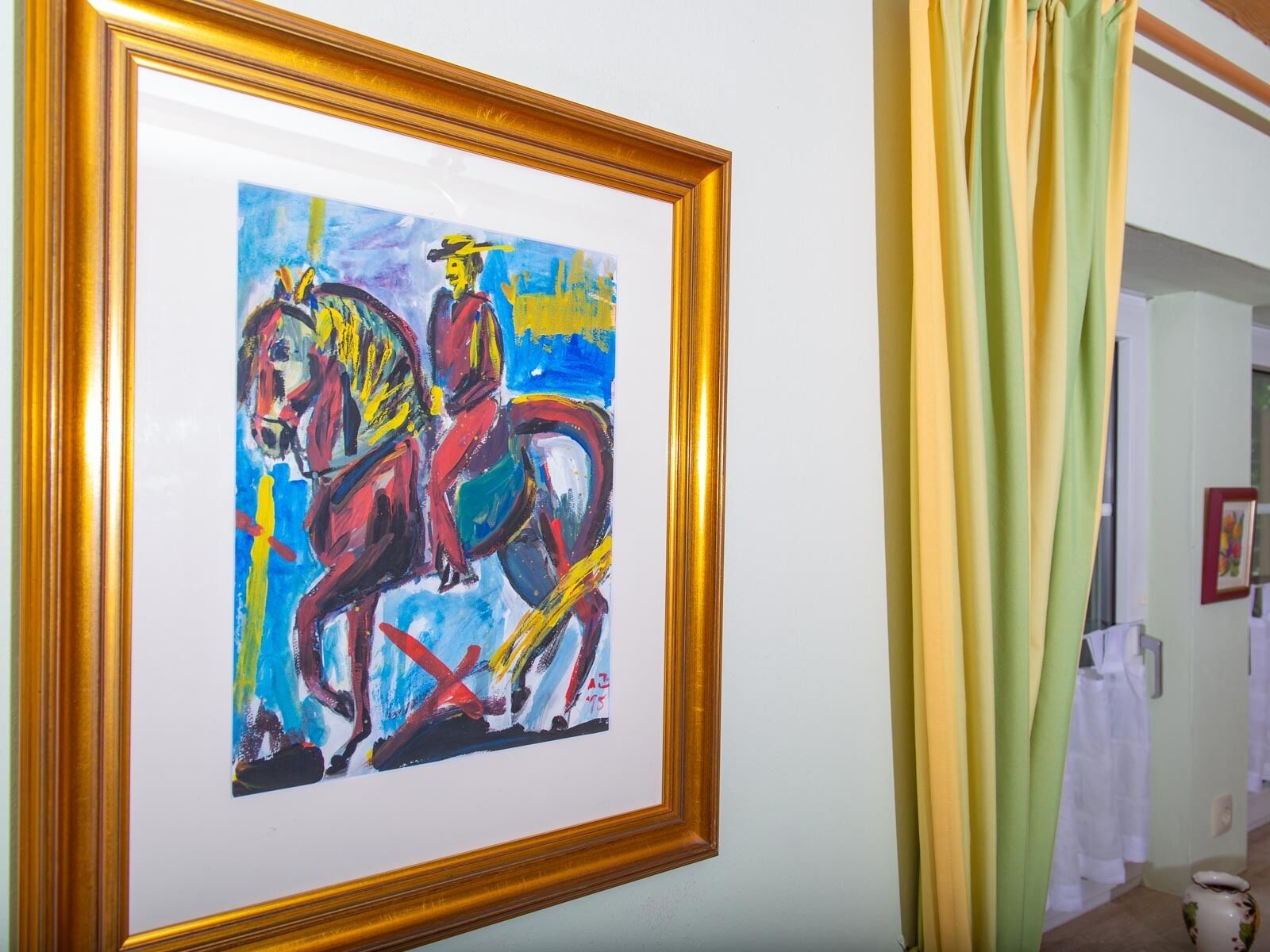 Un cuadro enmarco que muestra un jinete y un caballo.