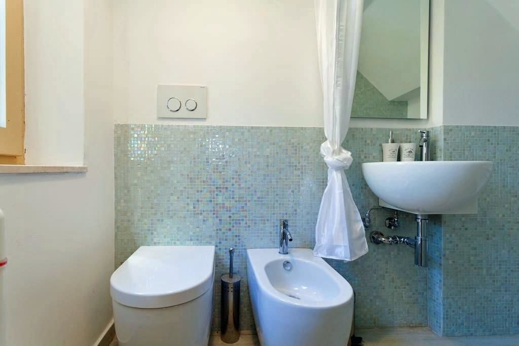 Un baño con inodoro, bidé y lavamanos.