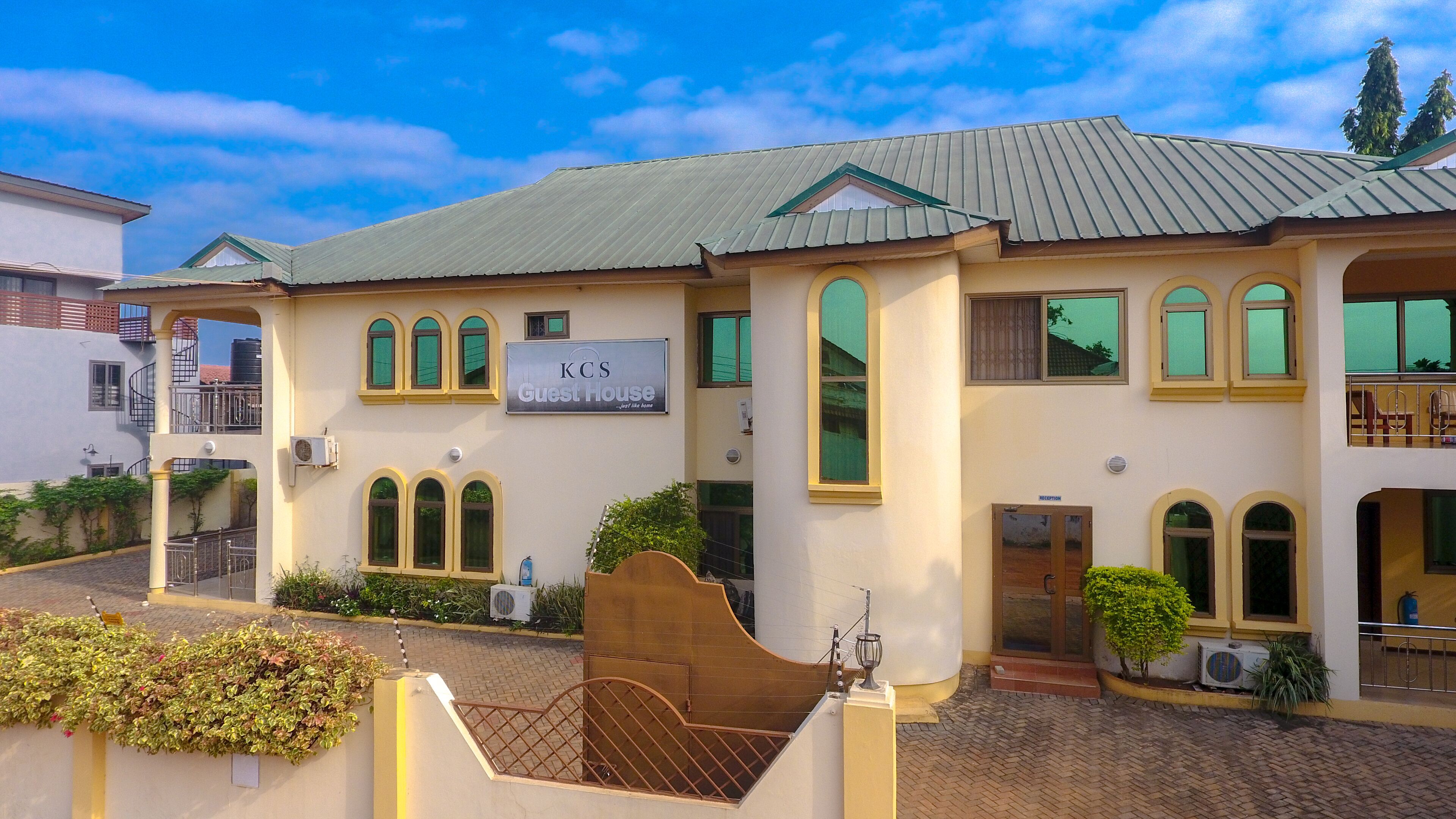 A two-story building with a sign reading "KCS Guest House."
