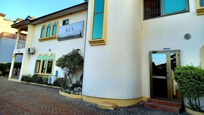 A building with a sign reading "KOS Guest House" and a reception area. - KCS Guest House (Accra)