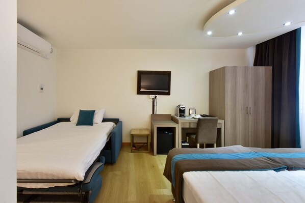 A hotel room with two beds, a desk, a chair, a television, and a wardrobe. - Hotel Rousseau Geneva (Geneva)