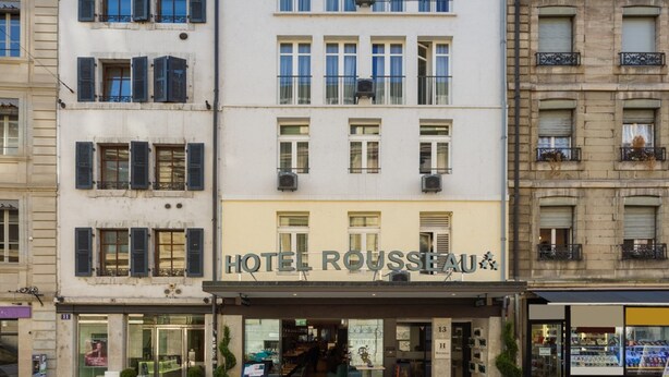 Un hôtel doté d’une façade moderne, de nombreuses fenêtres et d’une enseigne indiquant « HÔTEL RUSSEIA ».