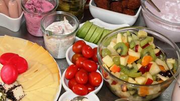 Ett urval av matvaror, inklusive en fruktsallad, ost och andra snacks.