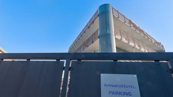 A multi-story building with a sign indicating 'APPORTA HOTEL PARKING'.