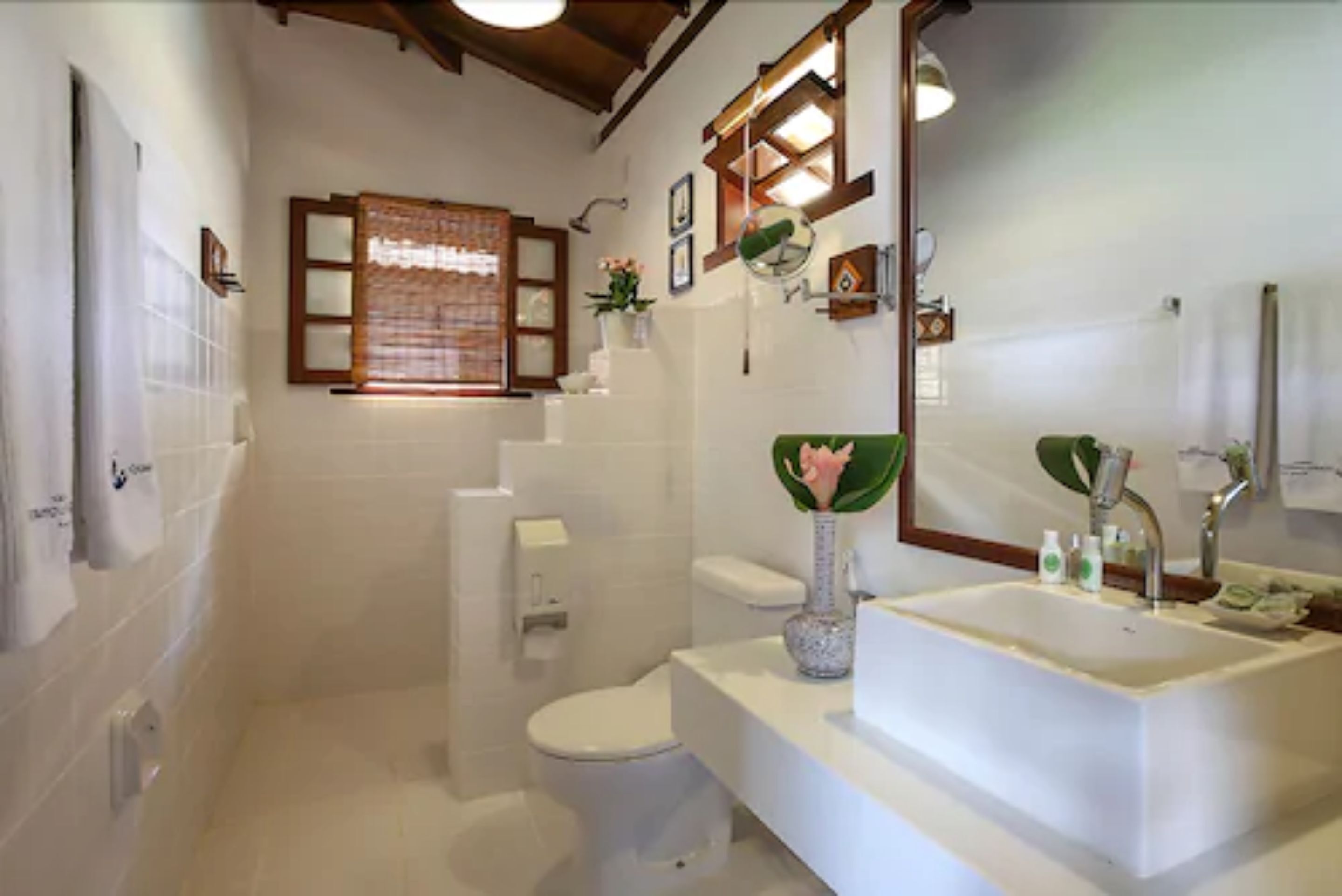 A bathroom with a toilet, sink, and shower.