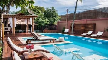 Alberca al aire libre, sombrillas en la alberca y camastros