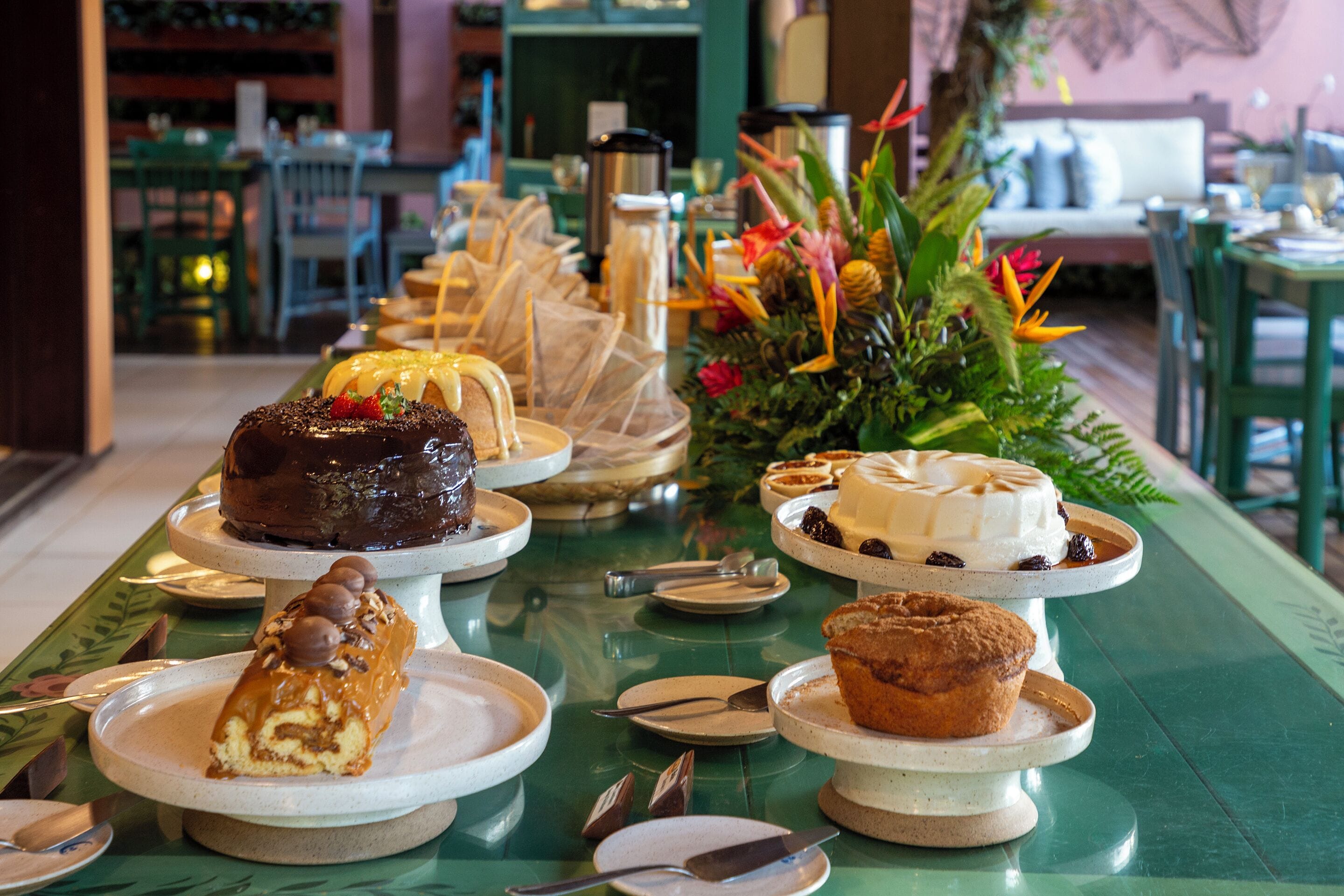 Ein Buffet mit verschiedenen Desserts und einer floralen Tischdekoration.