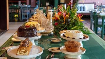 Ein Buffet mit verschiedenen Desserts und einer floralen Tischdekoration.