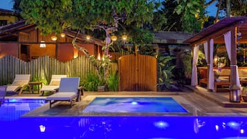 Alberca al aire libre, sombrillas en la alberca y camastros