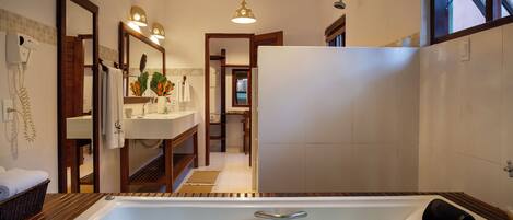 A modern bathroom with a bathtub, a shower, and a sink.