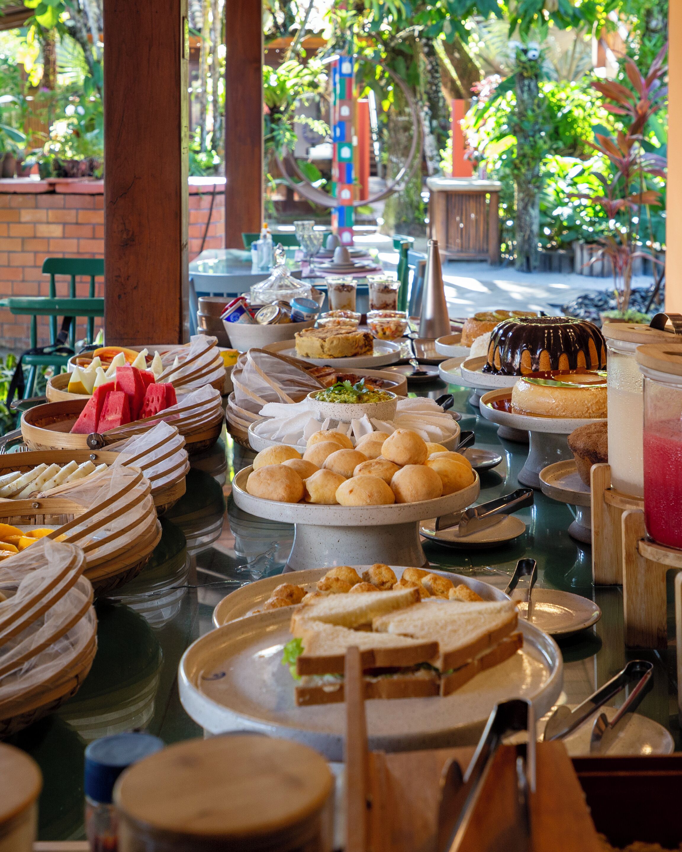 A buffet table with various food items and a glass of pink drink.