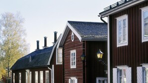 A row of wooden buildings with multiple windows and a central entrance with a door. - Grythyttans Gästgivaregård (Grythyttan)