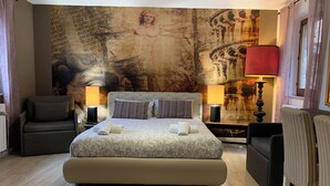 A bedroom with a large bed, two bedside tables with lamps, a chair, and a wall with a mural. - B&B Albornoz (Urbino)