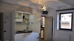 A modern kitchen with white cabinets, a built-in oven, and a window above the sink. - B&B Albornoz (Urbino)