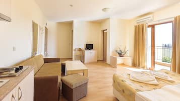 Apartamento superior, 1 quarto | Sala de estar | TV