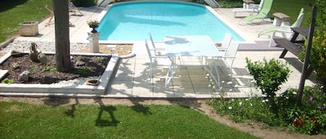 Una piscina cubierta, una piscina al aire libre, tumbonas