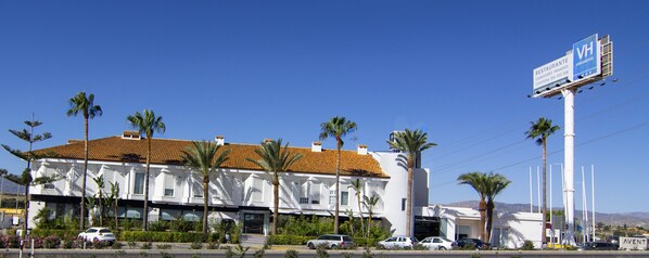 A white building with a tiled roof and palm trees in front. - Avent Verahotel (Vera)