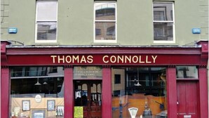 A storefront with the name "THOMAS CONNOLLY" above the entrance.