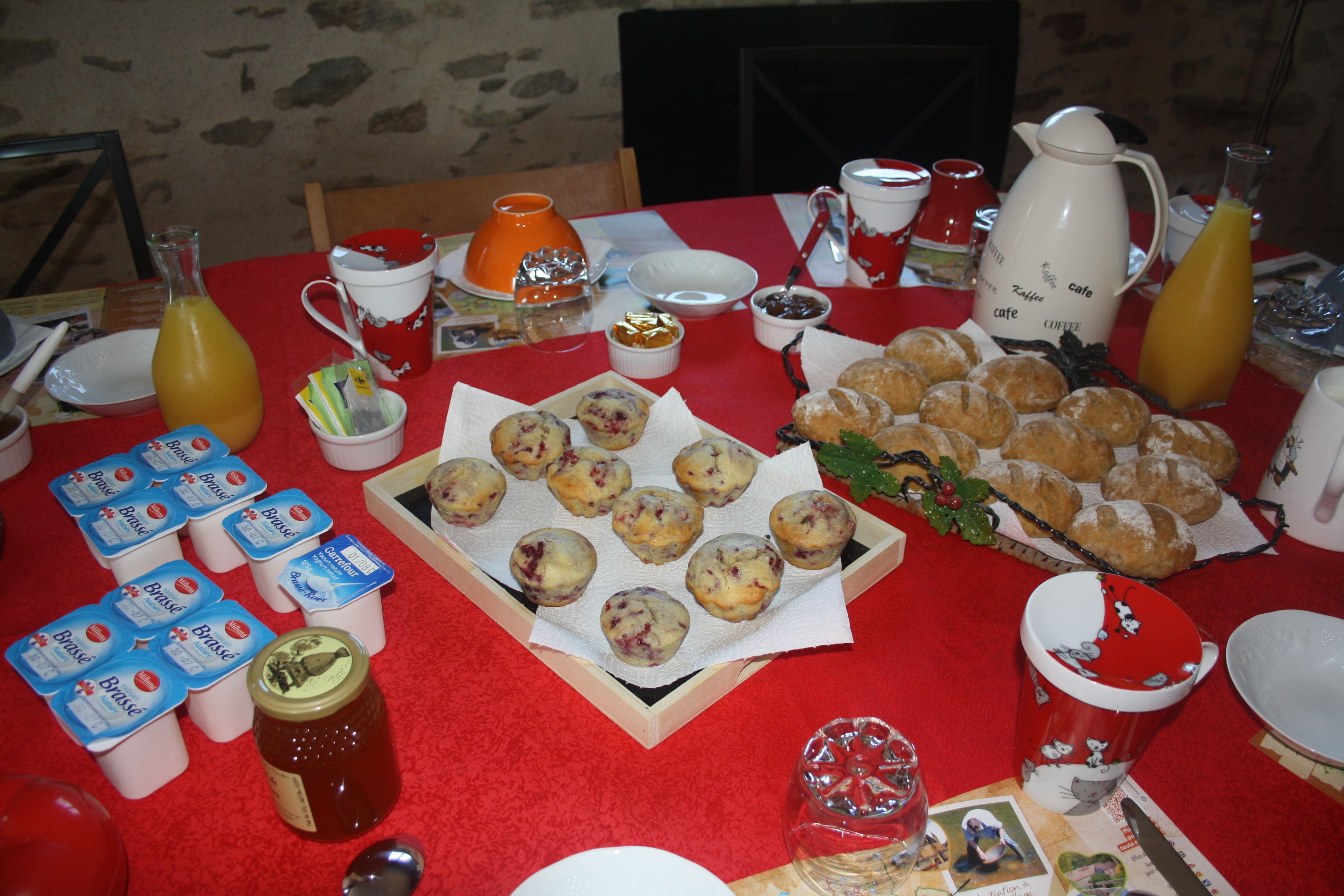 A breakfast table with various food items, including pastries, juice, and condiments.