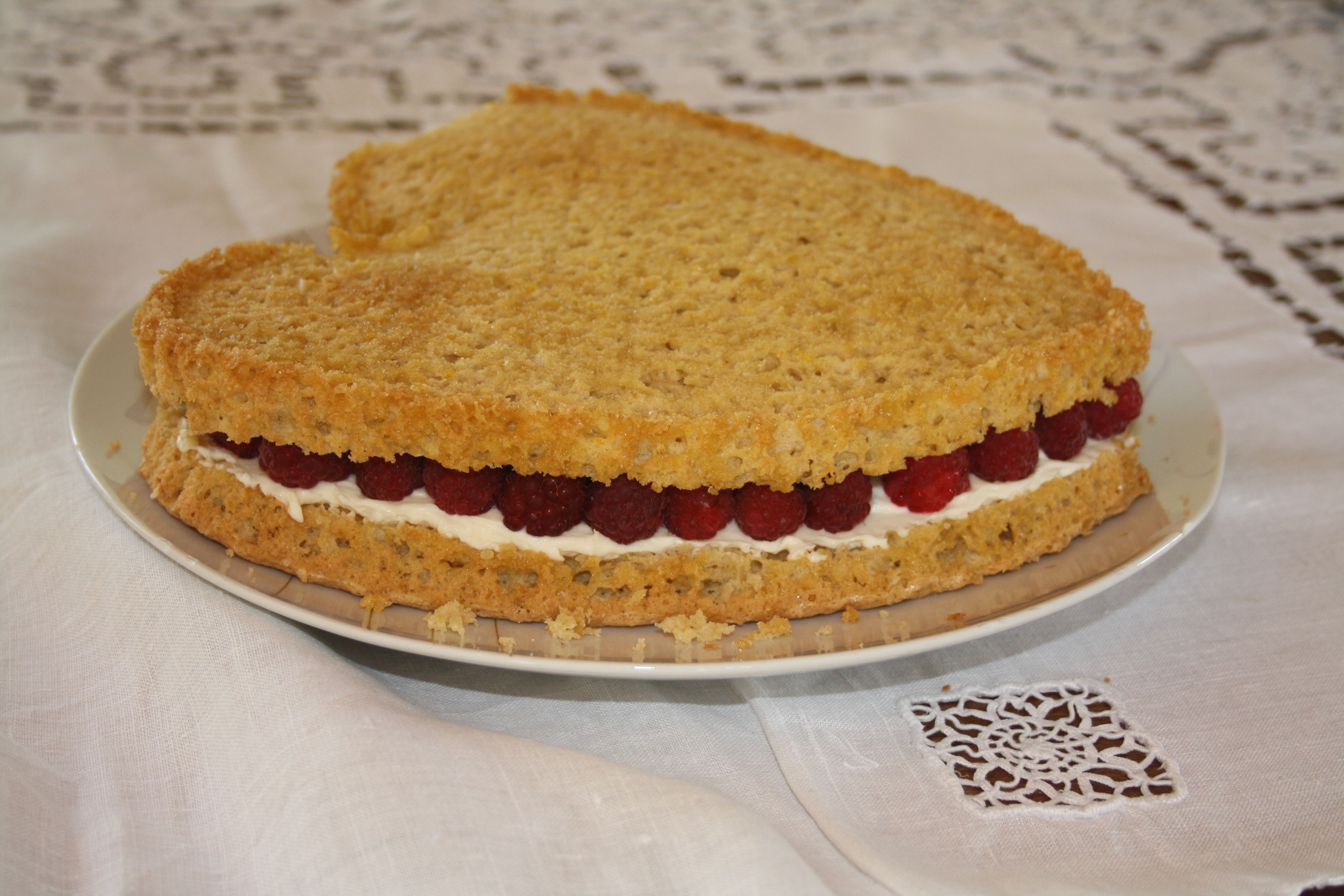 Un gâteau rond, avec une croûte friable et une garniture crémeuse, servi sur une assiette blanche.