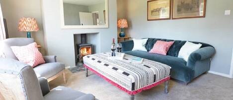 A living room with a fireplace, a sofa, a chair, and a coffee table.