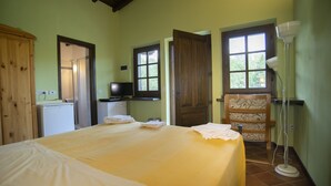 A room with a bed, a desk, a television, and a wardrobe. - Agriturismo Il Corniolo (Castiglione di Garfagnana)