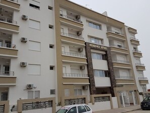 A multi-story residential building with balconies, air conditioning units, and a sign reading "RESIDENCE IBTIHEL". - Maryouma Appart (Nabeul)