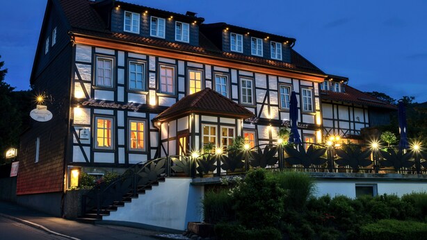 Un edificio europeo tradicional con numerosas ventanas, una escalera e iluminación exterior.