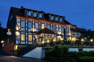 Un edificio europeo tradicional con numerosas ventanas, una escalera e iluminación exterior.