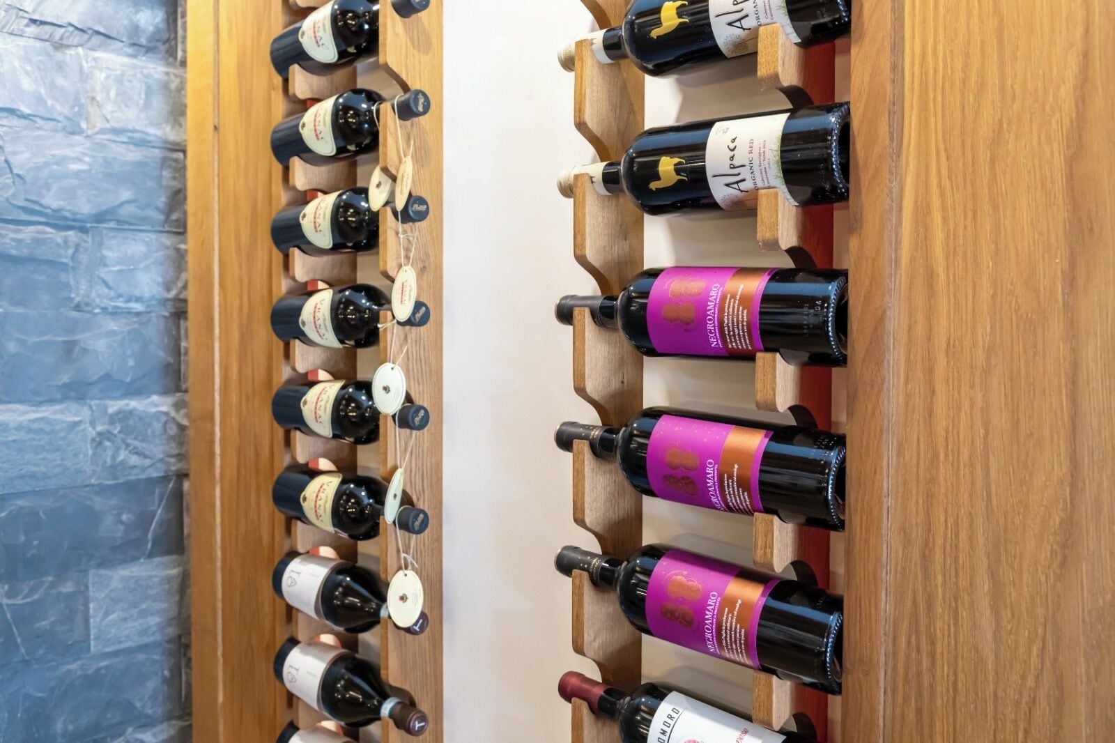 A wine rack with bottles of wine, some with purple labels.