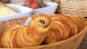 Una cesta de croissants sobre una mesa.