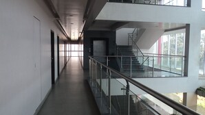 A modern building with a long, narrow corridor leading to a staircase. - Royal Hills Vasai - Thane (Vasai)