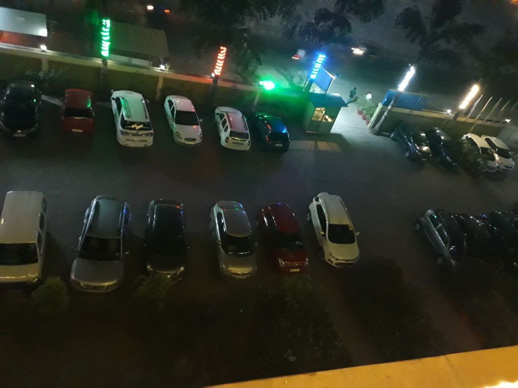 A parking lot with several cars parked in rows.