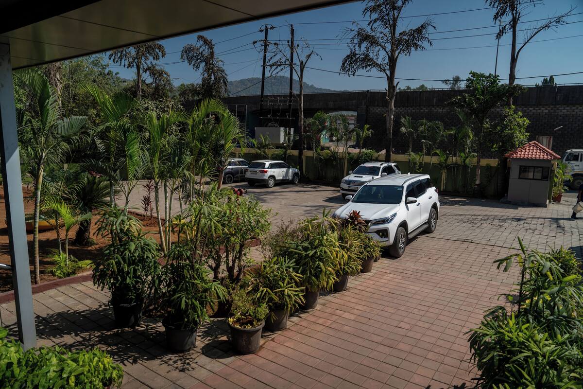 Um espaço de estacionamento com vários carros e plantas em vasos.