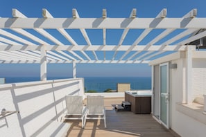 A balcony with a white pergola, two white chairs, a hot tub, and a view of the ocean. - Marivent Apartments by Brava Hoteles (Calonge)
