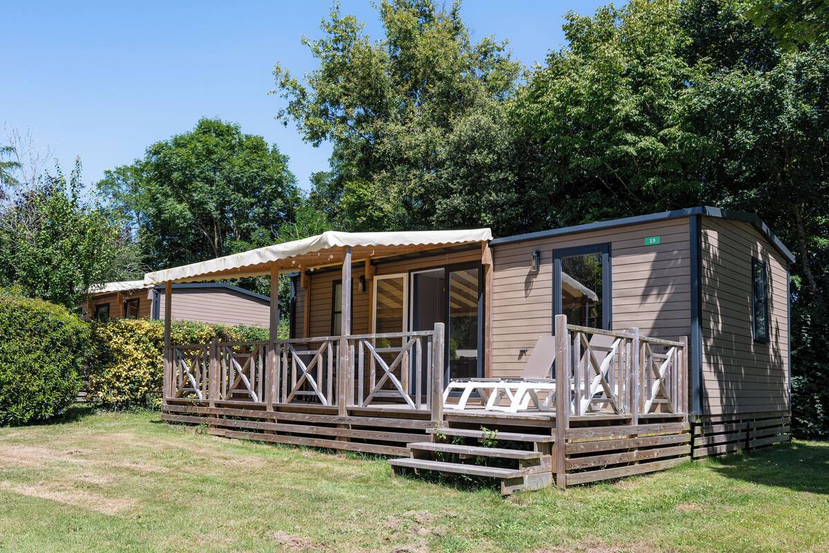 Ein Bungalow mit Veranda und überdachter Sitzgelegenheit im Freien.