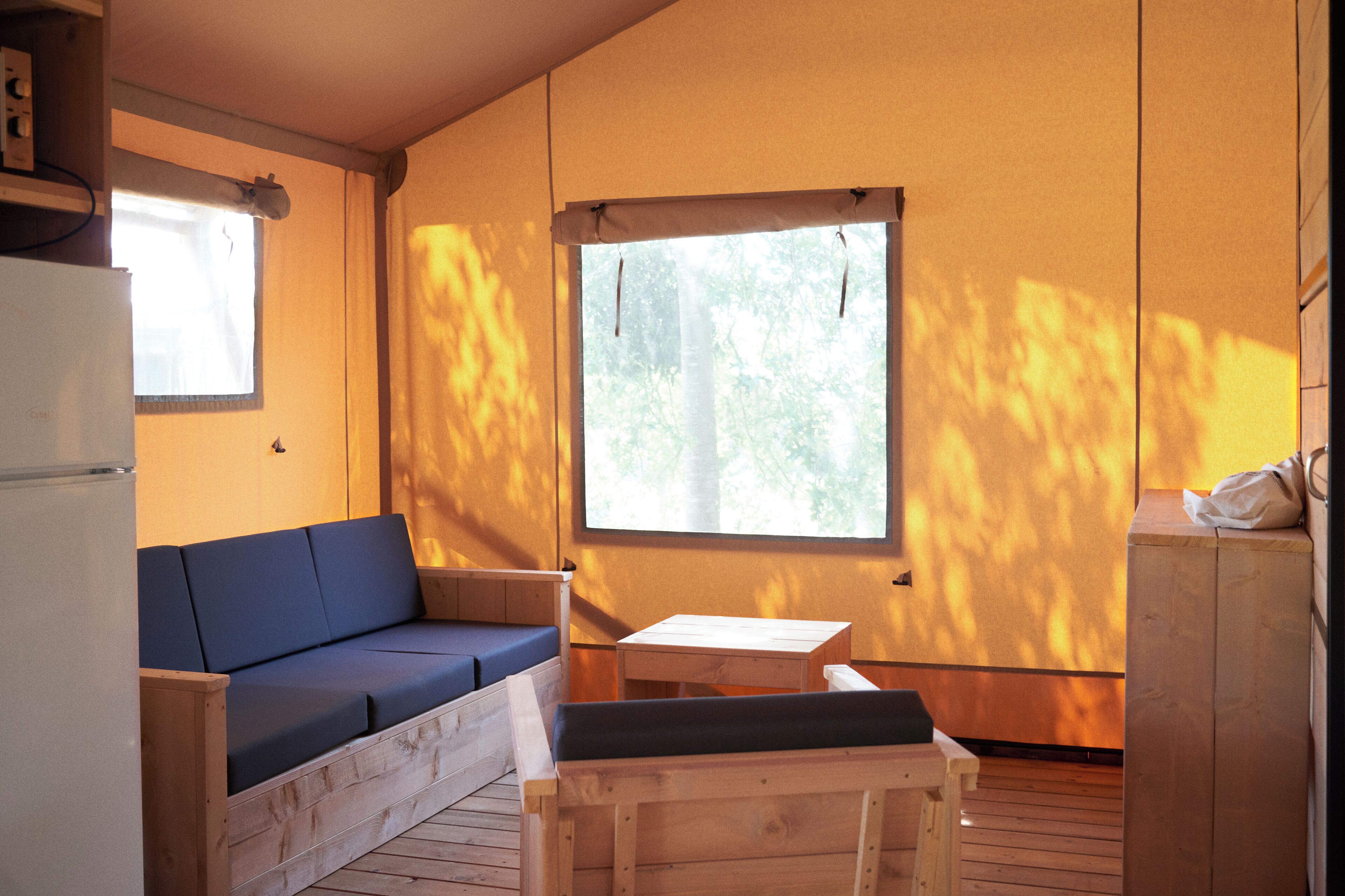 A small, cozy room with a wooden bench, a sofa, and a table.