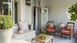 A cozy room with a sofa, two chairs, a small table, and a potted plant.