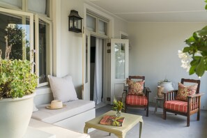 A cozy room with a sofa, two chairs, a small table, and a potted plant.
