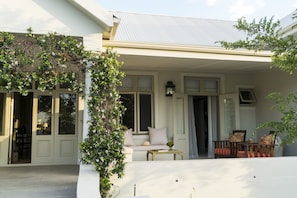 A covered porch with a seating area, a table, and chairs.