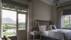 Une chambre à coucher avec un lit, une table de chevet et une vue sur un paysage.
