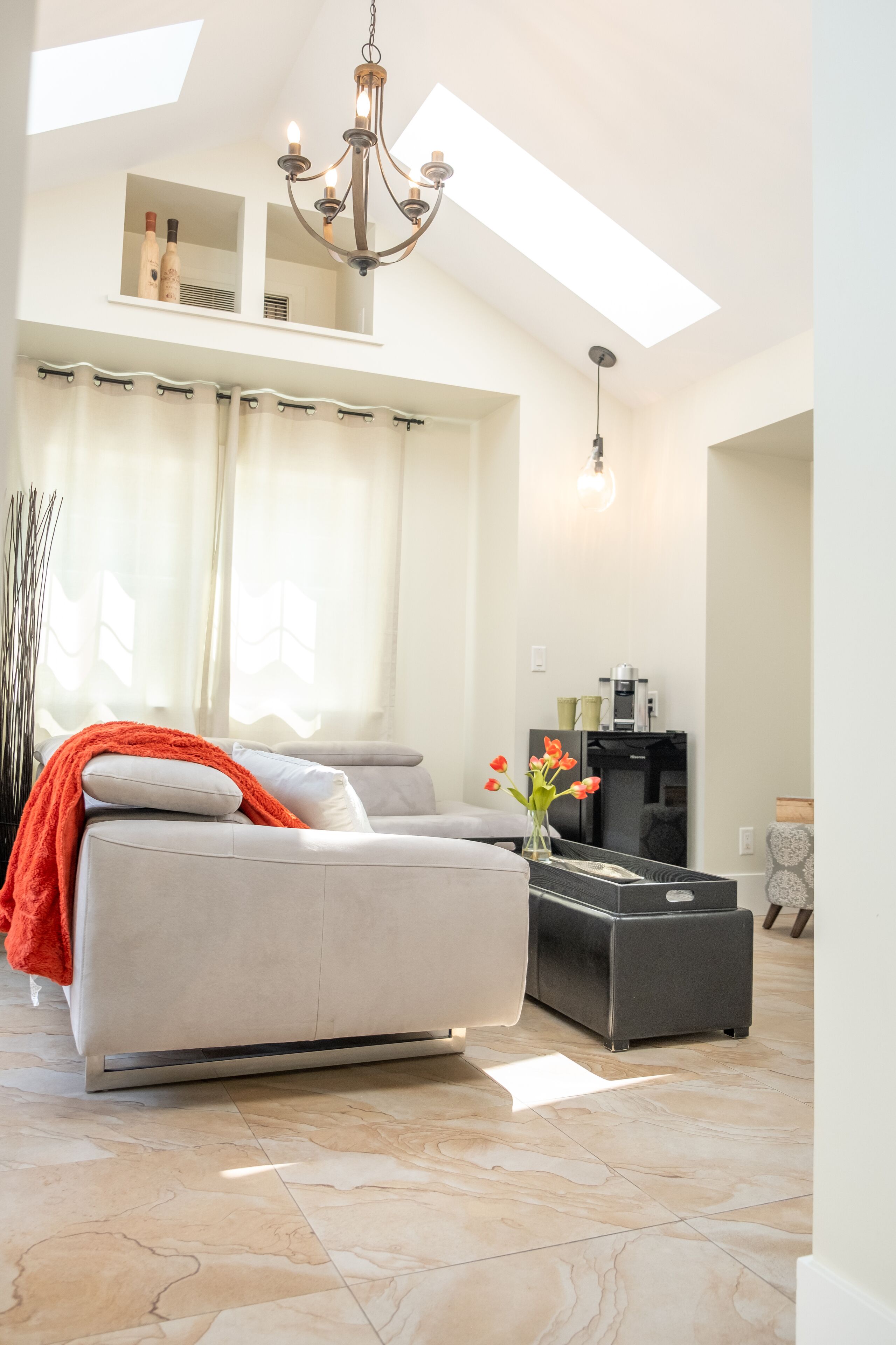 Een moderne woonkamer met een bank, een salontafel en een kroonluchter.