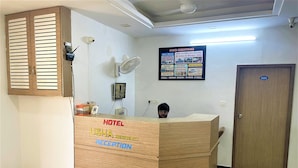 A hotel reception desk with a sign indicating it's the Usha Residency Reception.