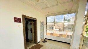 A hallway leading to a Usha Residency on the 2nd floor, with a fire extinguisher and a doormat on the floor.