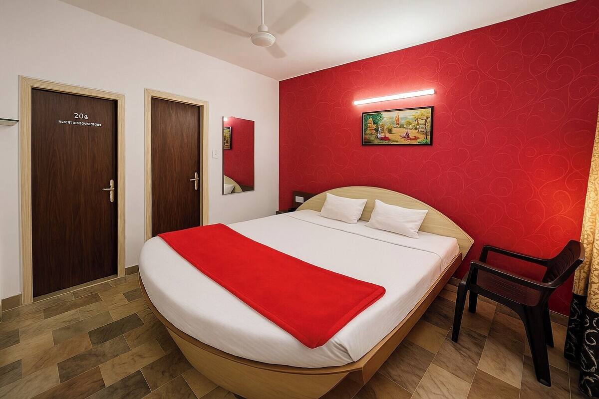 Habitación de hotel con una cama grande, una pared de acento roja y suelo de madera.