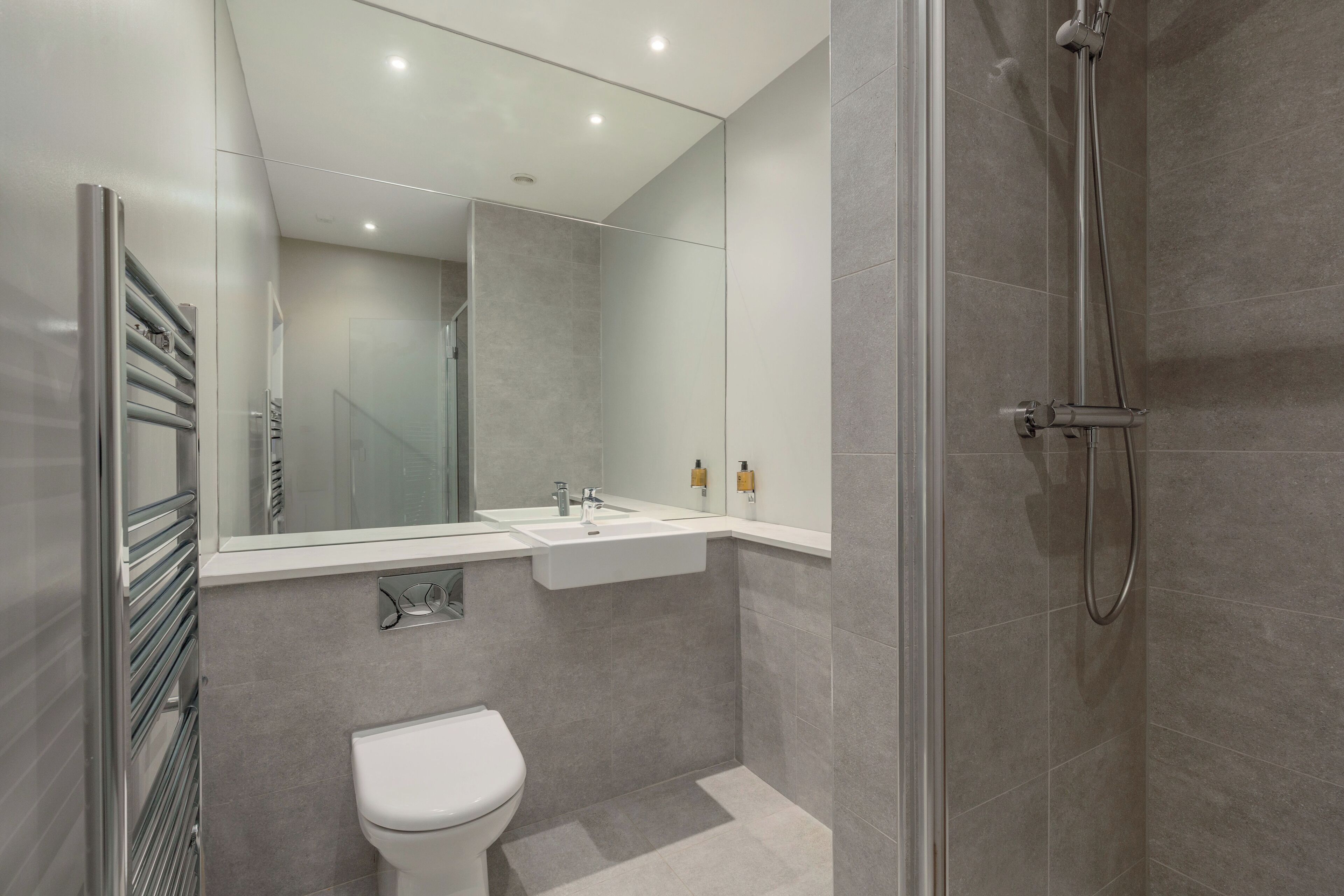 Un baño moderno con ducha, inodoro y lavamanos.