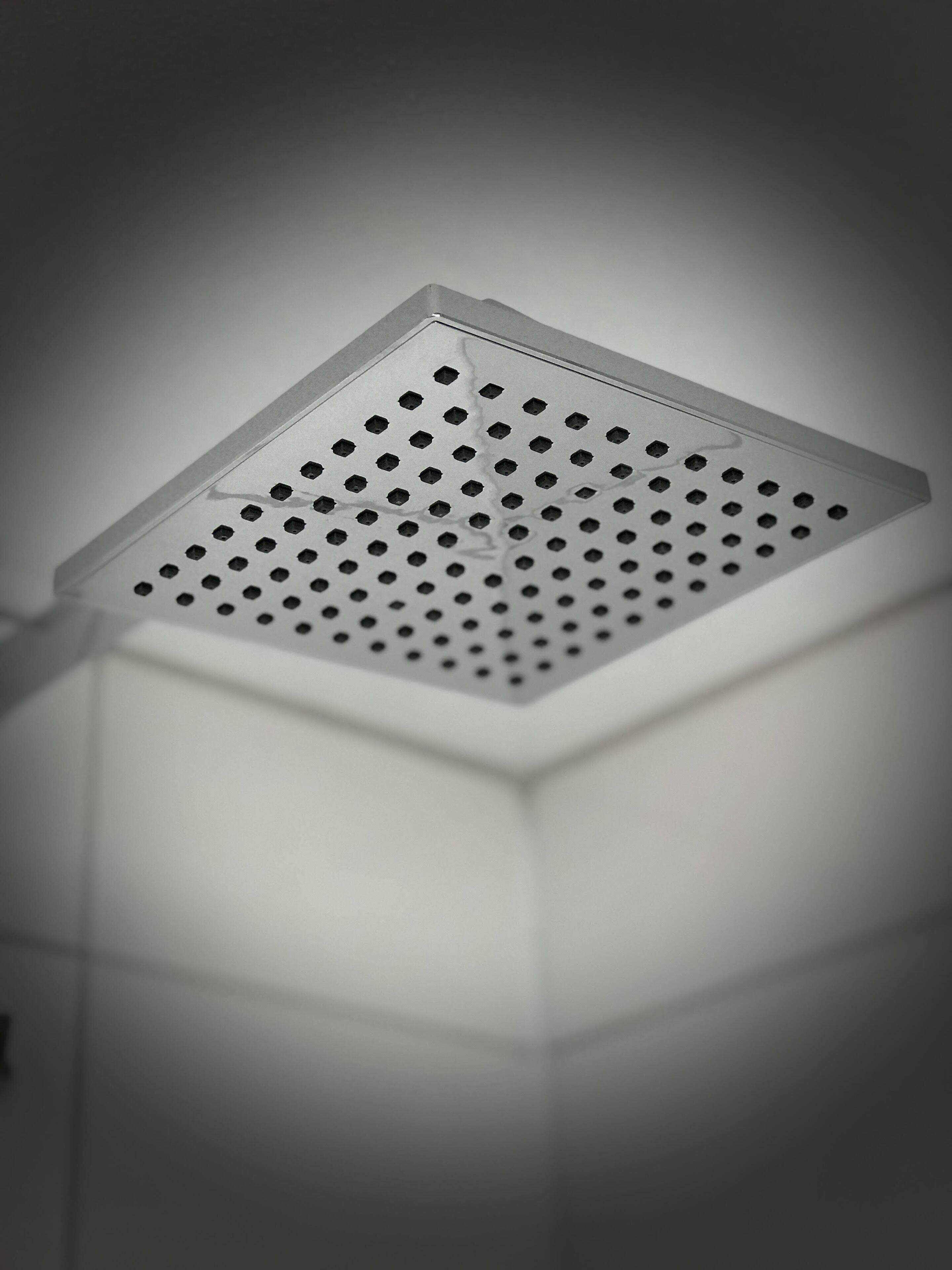 A ceiling with a square, perforated design, likely a vent or light fixture.