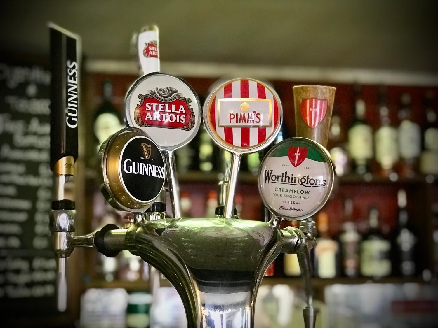 A bar tap with multiple beer taps including brands like Guinness, Stella Artois, Pima's, and Worthington's.